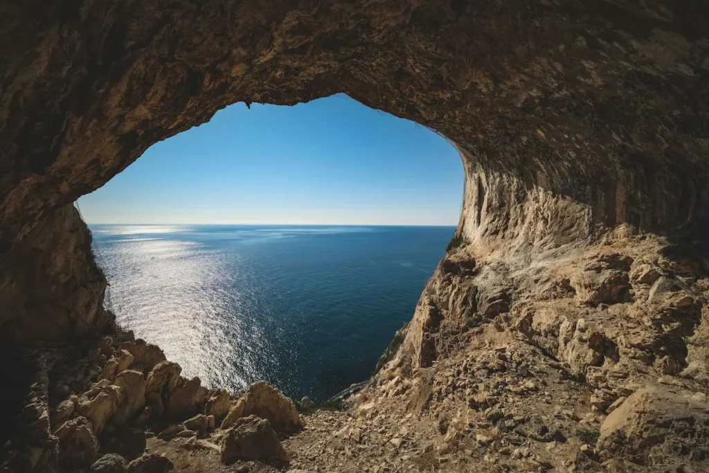 Vista del mar a través de una abertura en una cueva de roca, simbolizando la esperanza y el inicio de un nuevo proyecto de vida.